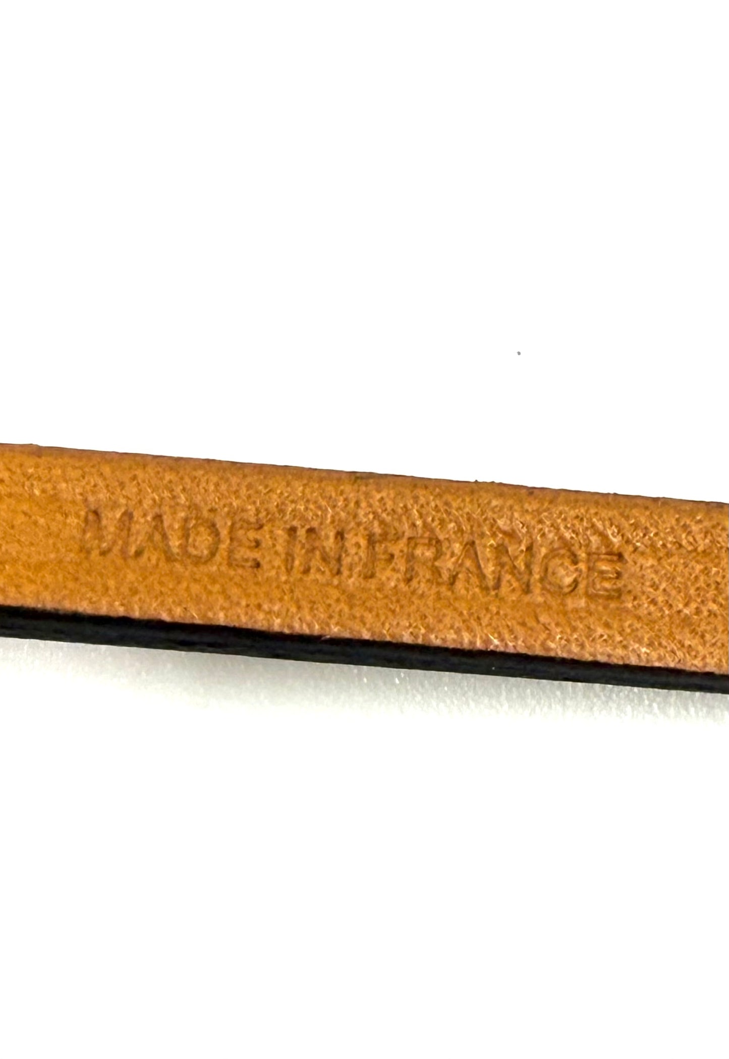 Präzise Prägung "Made in France" auf braunem Leder des HERMÈS Oran Nano Anhängers in Nahaufnahme.