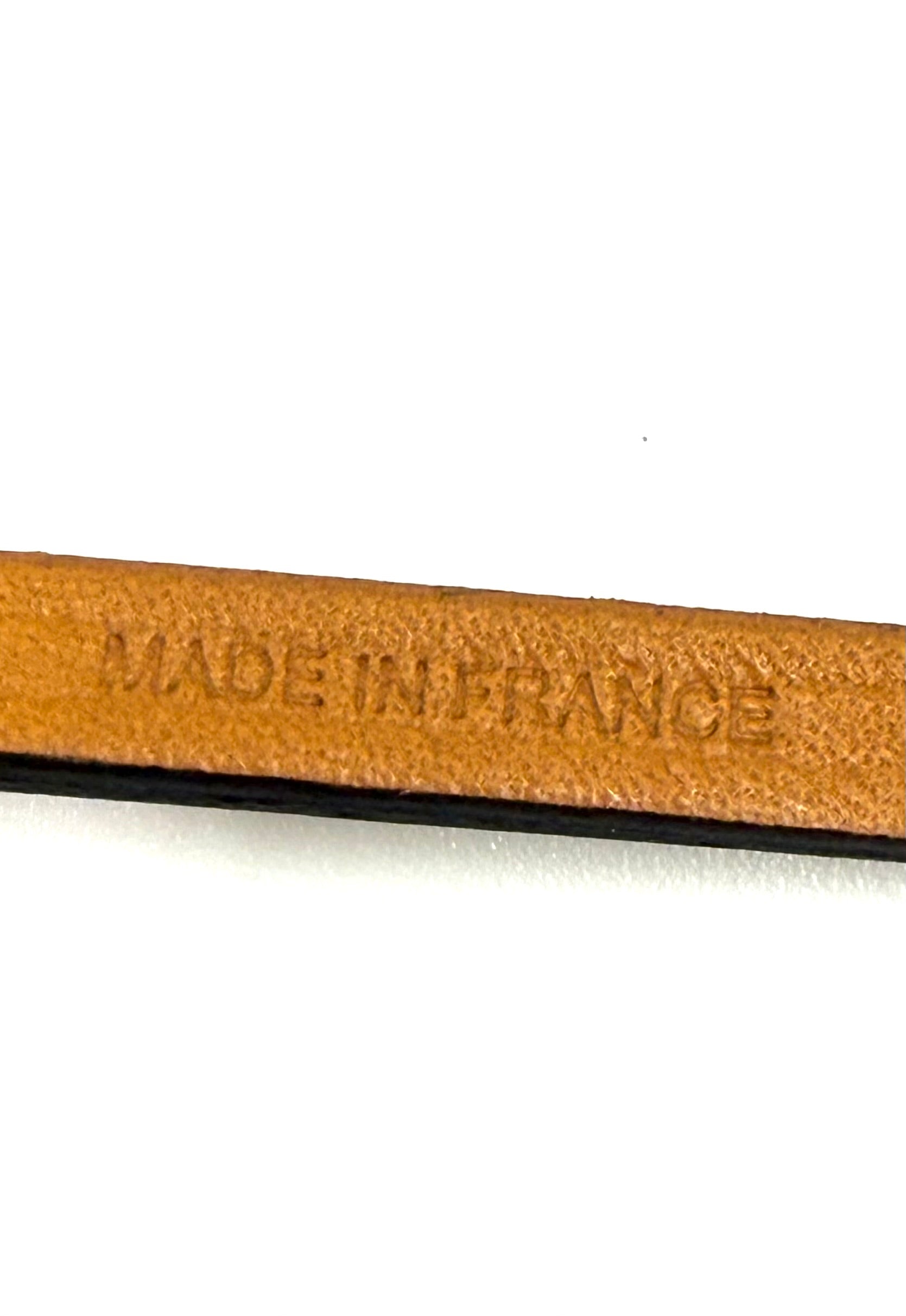 Präzise Prägung "Made in France" auf braunem Leder des HERMÈS Oran Nano Anhängers in Nahaufnahme.