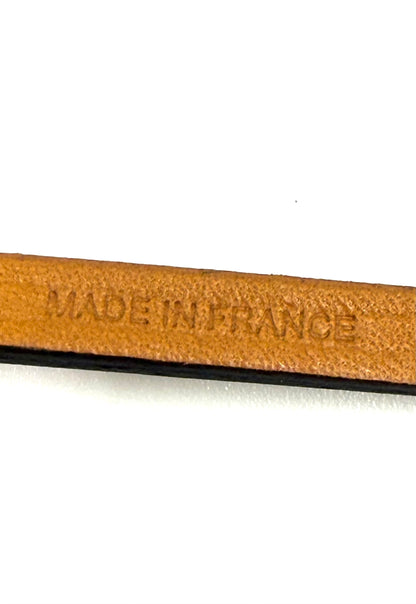 Präzise Prägung "Made in France" auf braunem Leder des HERMÈS Oran Nano Anhängers in Nahaufnahme.
