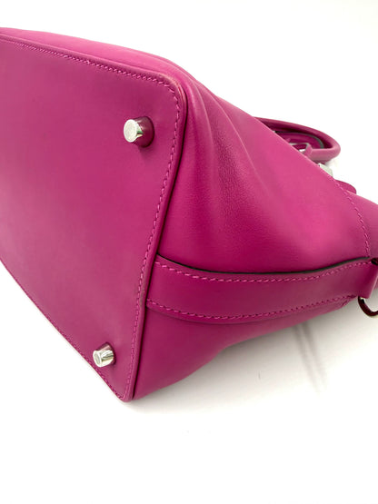 Detailaufnahme der Bodenpartie der HERMÈS Toolbox 22 fuchsia PHW aus hochwertigem Leder mit Metallfüßen.