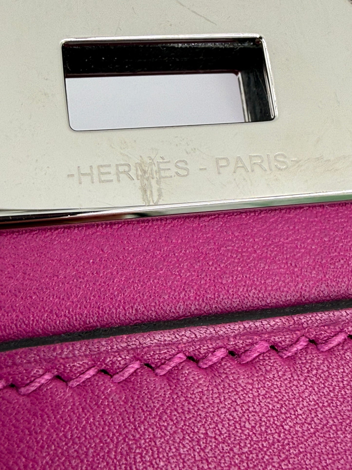 HERMÈS Toolbox 22 fuchsia PHW Nahaufnahme der pinken Lederhandtasche mit silbernem Verschluss und Prägung Hermès Paris