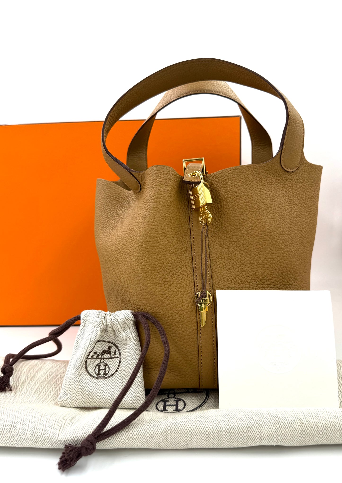 HERMÈS Picotin 22 Lock Clemenceleder Biscuit GHW in Braun mit Goldverschlüssen vor orangefarbener Schachtel