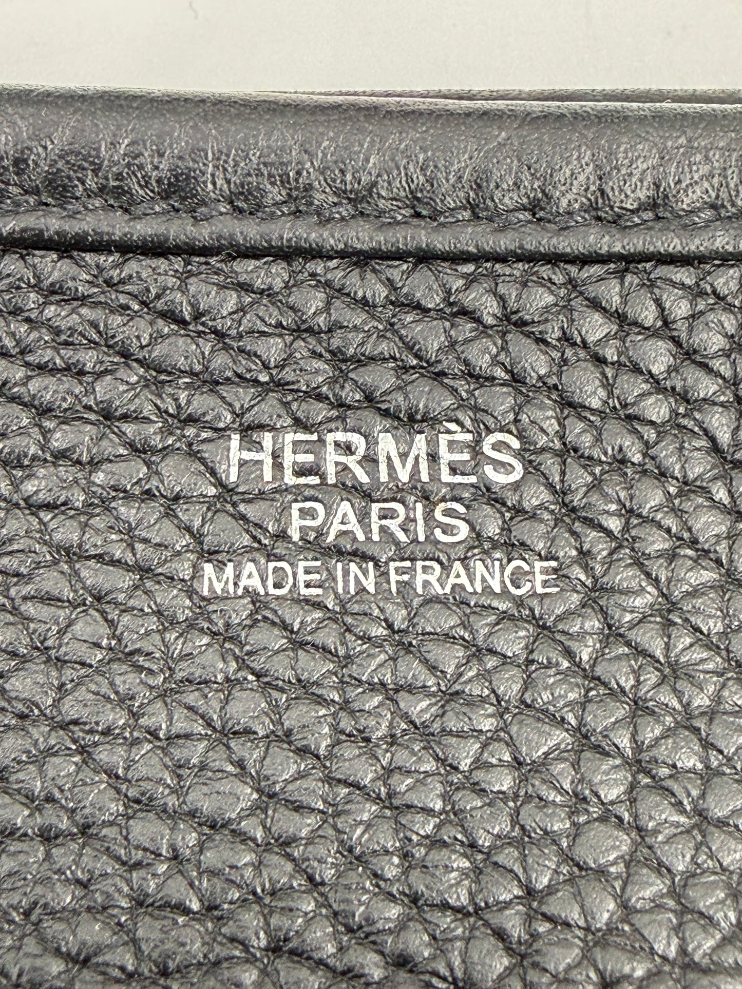 Prägung auf schwarzem Leder mit Schriftzug HERMÈS Evelyne 29 schwarz PHW, Made in France, Detailansicht.