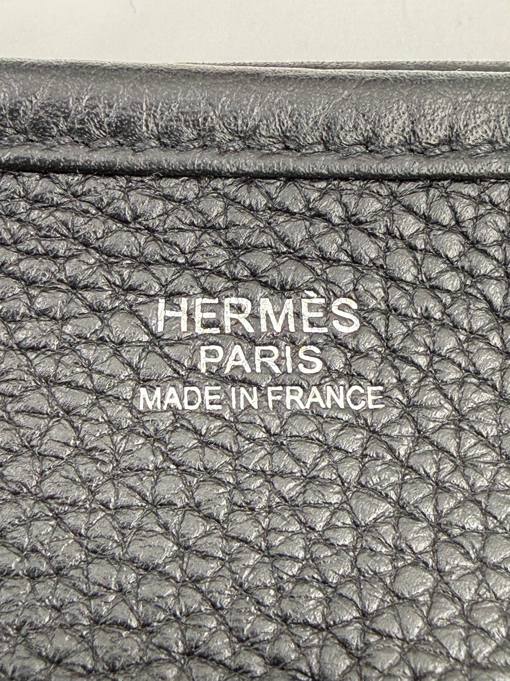 Prägung auf schwarzem Leder mit Schriftzug HERMÈS Evelyne 29 schwarz PHW, Made in France, Detailansicht.