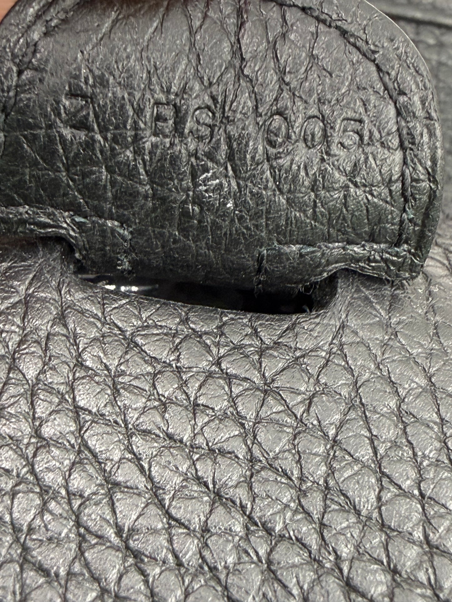 Nahaufnahme der schwarzen Ledernarbung und Prägung der HERMÈS Evelyne 29 schwarz PHW Designerhandtasche.