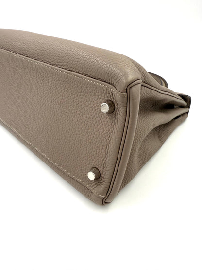 HERMÈS Kelly 32 Retourne Gris Asphalte PHW Lederboden mit Palladium-Füßen und feiner Nahtqualität.