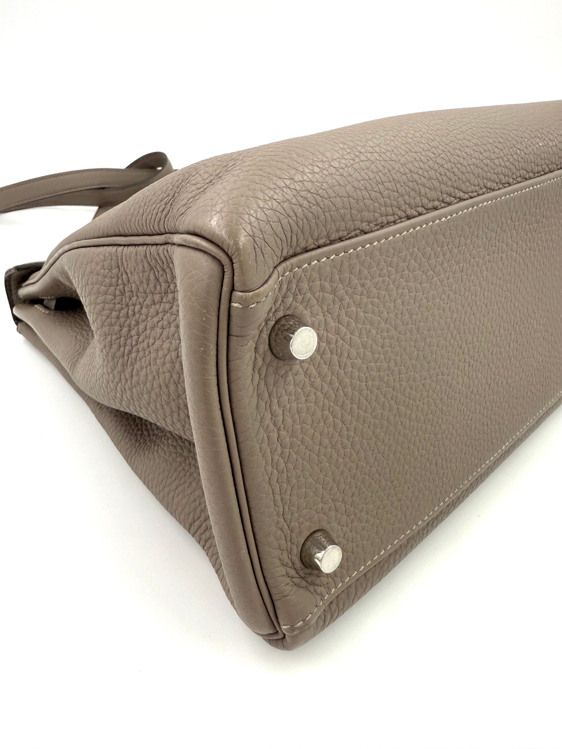 HERMÈS Kelly 32 Retourne Gris Asphalte PHW Detailaufnahme der Bodenecke mit Palladium-Hardware und Clemence Lederstruktur.