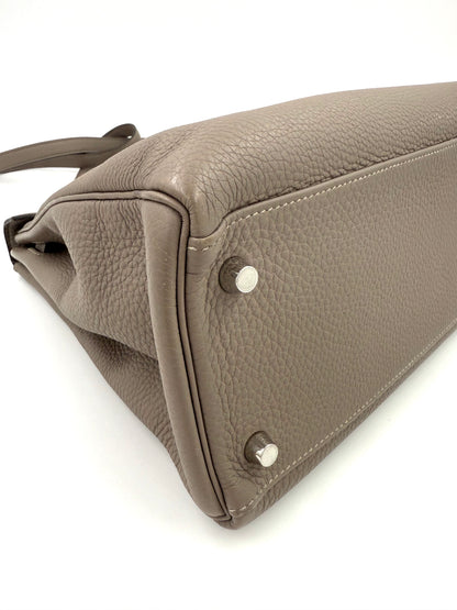 HERMÈS Kelly 32 Retourne Gris Asphalte PHW Detailaufnahme der Bodenecke mit Palladium-Hardware und Clemence Lederstruktur.