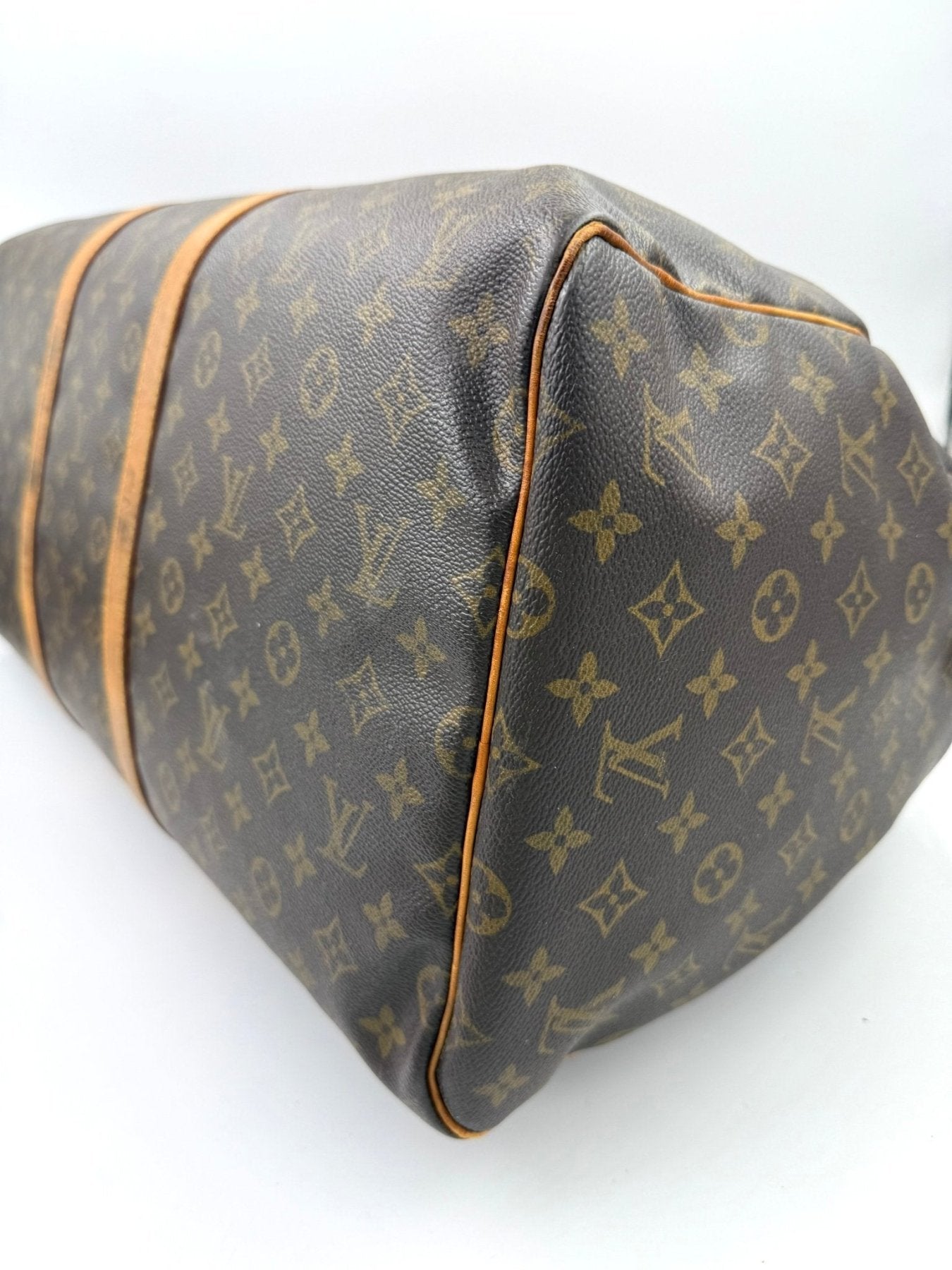 Louis Vuitton Keepall 55 Reisetasche in Monogram Canvas mit braunem Lederbesatz und charakteristischem LV Muster Seitenansicht