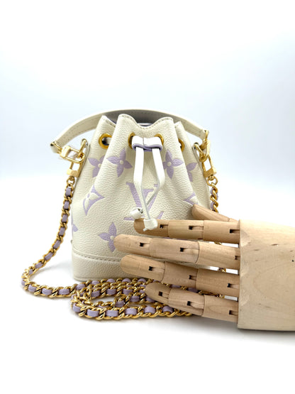 LOUIS VUITTON Nano Noe Monogram Empreinte in creme und flieder mit goldfarbener Kette und Zugverschluss, neuwertig