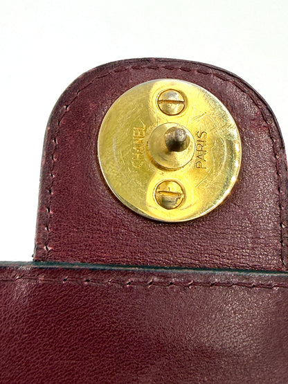 CHANEL Single Flap Square medium bordeaux GHW Detailaufnahme des goldfarbenen Verschlusses auf feinem Leder