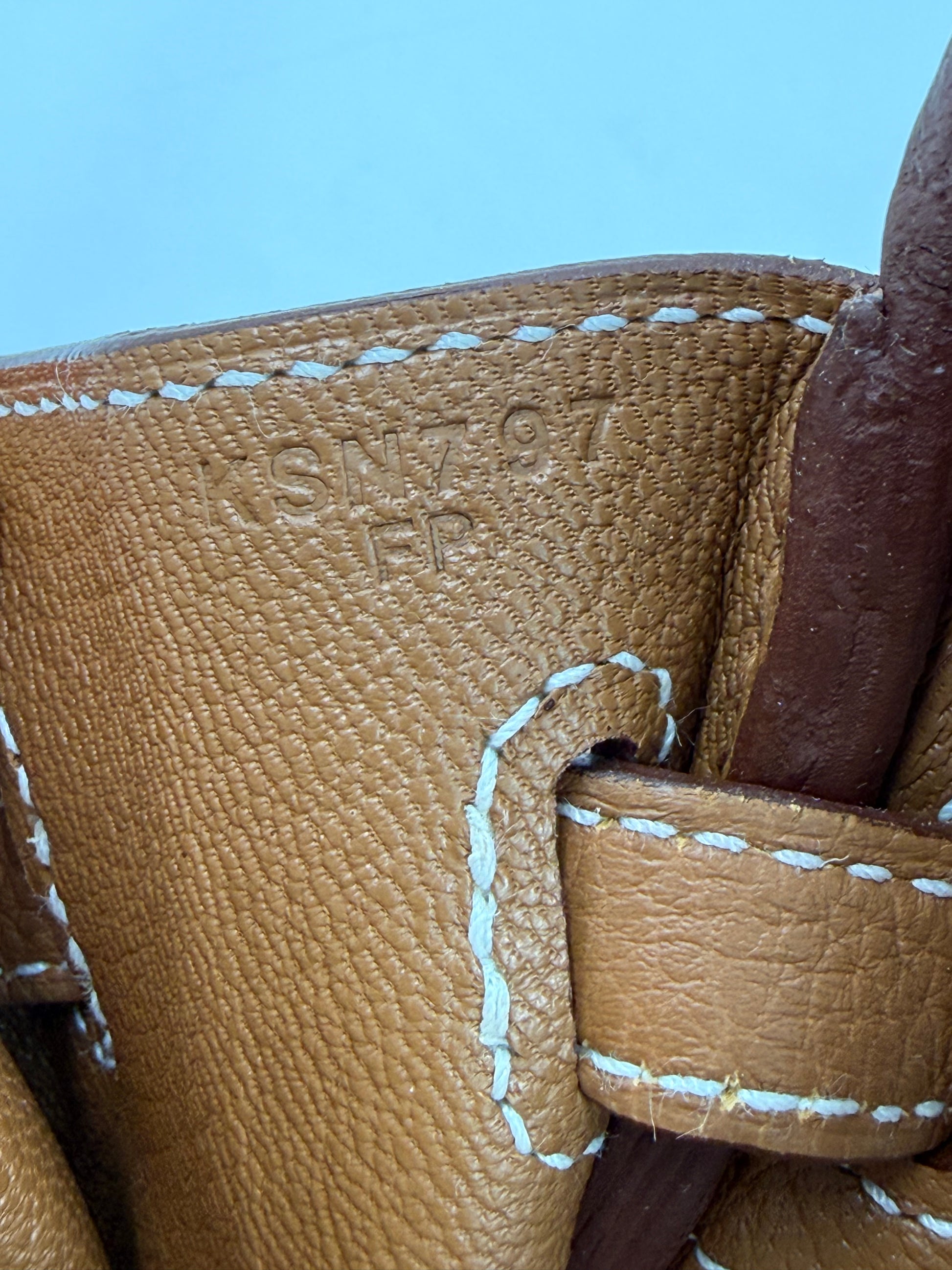 HERMÈS Birkin 25 Togo Gold GHW Fullset Nahaufnahme der Prägung und feiner weißer Ziernähte auf braunem genarbtem Leder