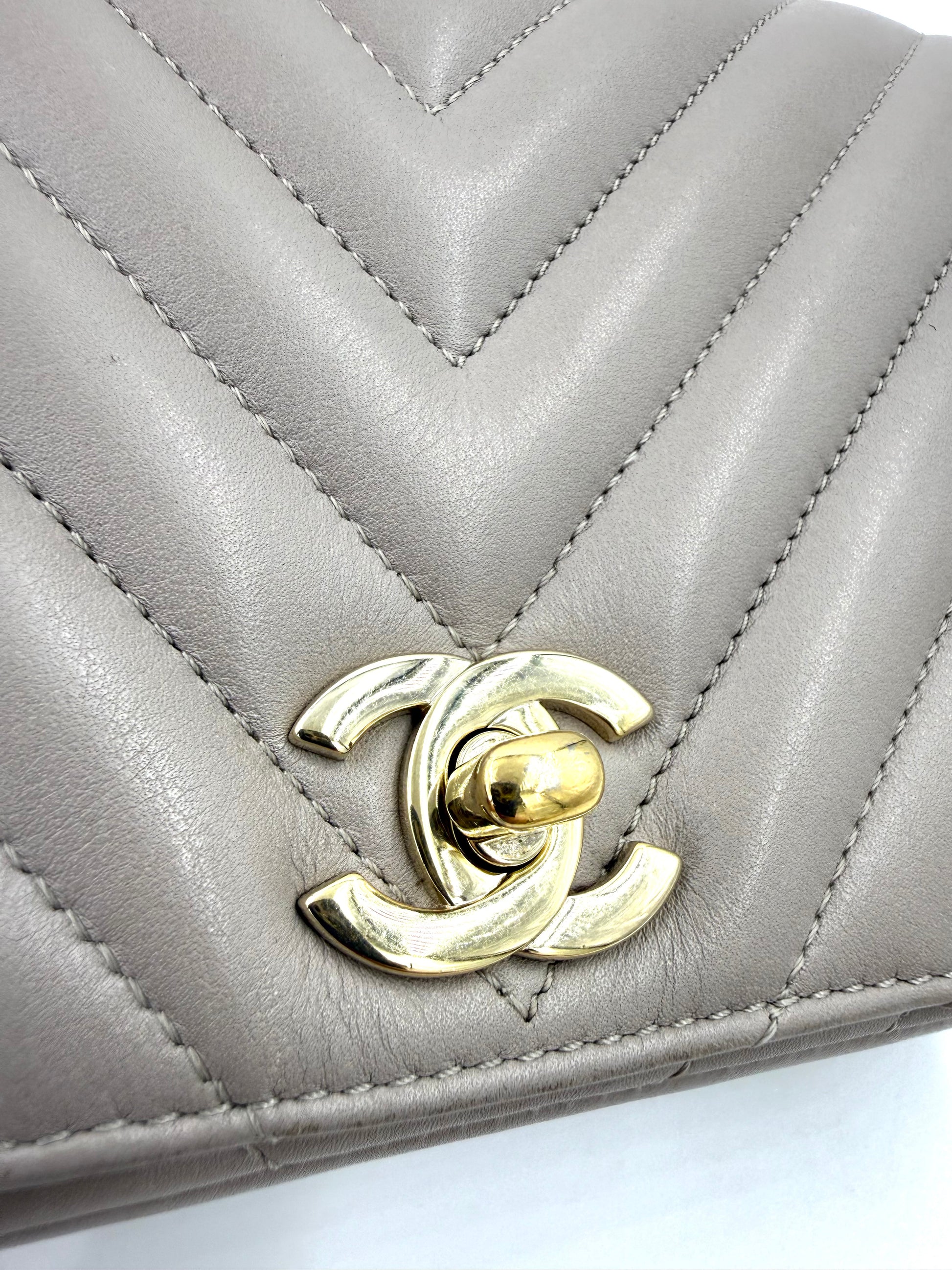 CHANEL Timeless Single Flap Bag Chevron taupe GHW Detailansicht des goldfarbenen Drehverschlusses im gesteppten Leder