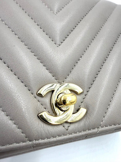 CHANEL Timeless Single Flap Bag Chevron taupe GHW Detailansicht des goldfarbenen Drehverschlusses im gesteppten Leder