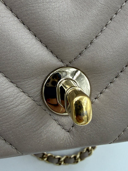 CHANEL Timeless Single Flap Bag Chevron taupe GHW Nahaufnahme des goldfarbenen Drehverschlusses und gestepptem Leder