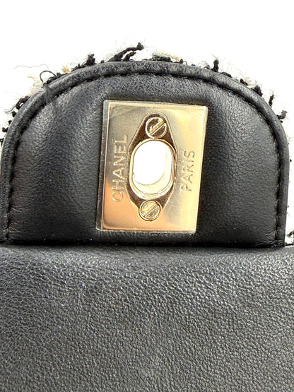 Schließelement mit graviertem CHANEL Flap Bag Tweed schwarz/weiß GHW Logo in schwarzem Lederimitat.