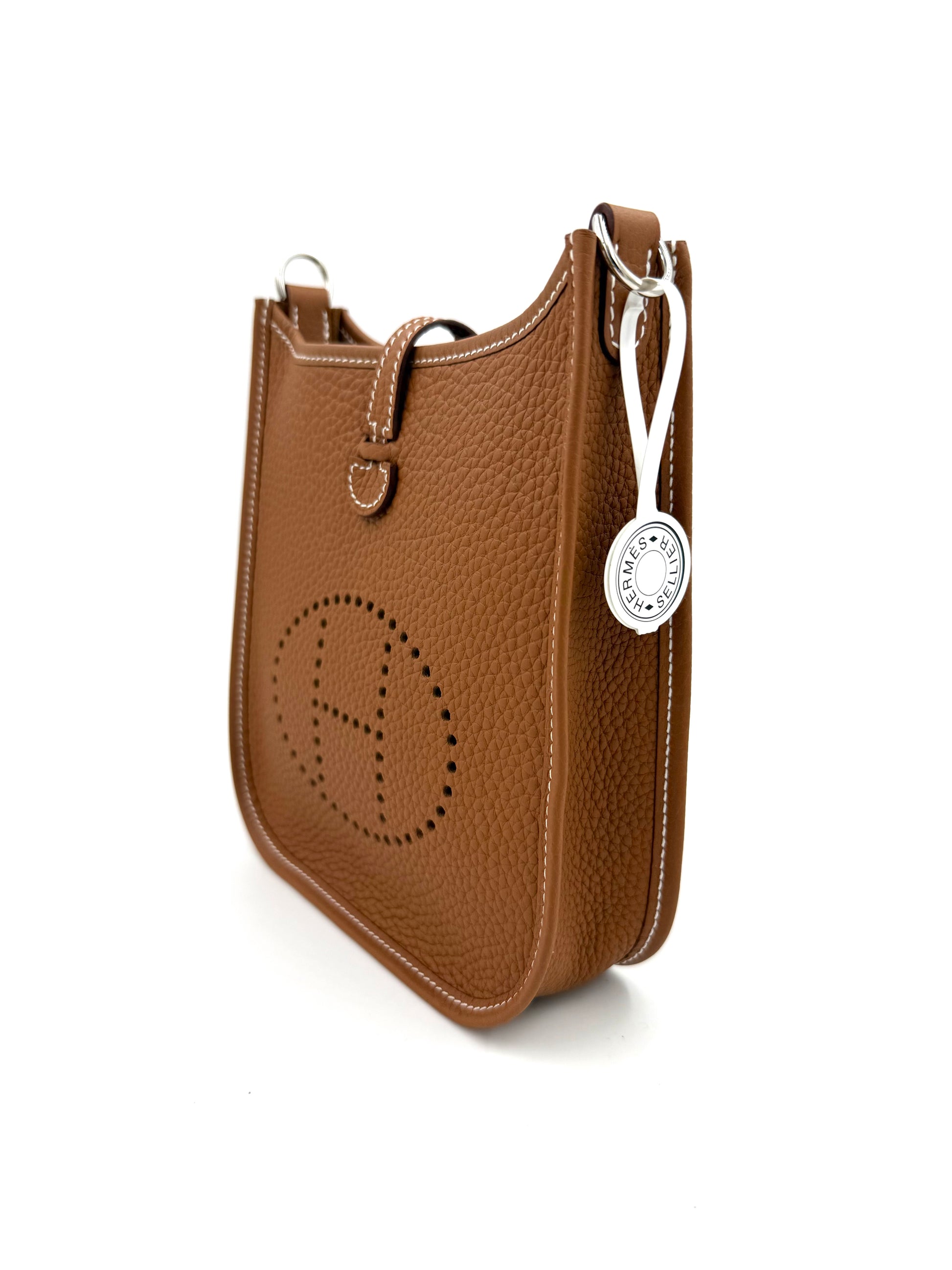 HERMÈS Evelyne 16 gold PHW aus hochwertigem cognacfarbenem Leder mit feiner Naht und silbernem Anhänger.