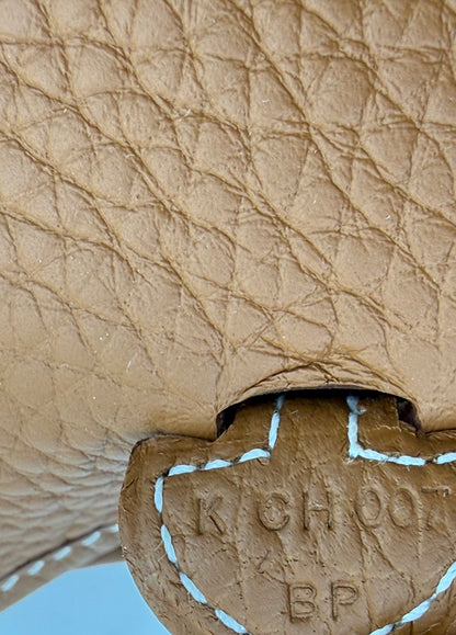 Detailaufnahme des feinen Leders der HERMÈS Evelyne 16 gold PHW mit handgenähten weißen Nähten und Prägung.