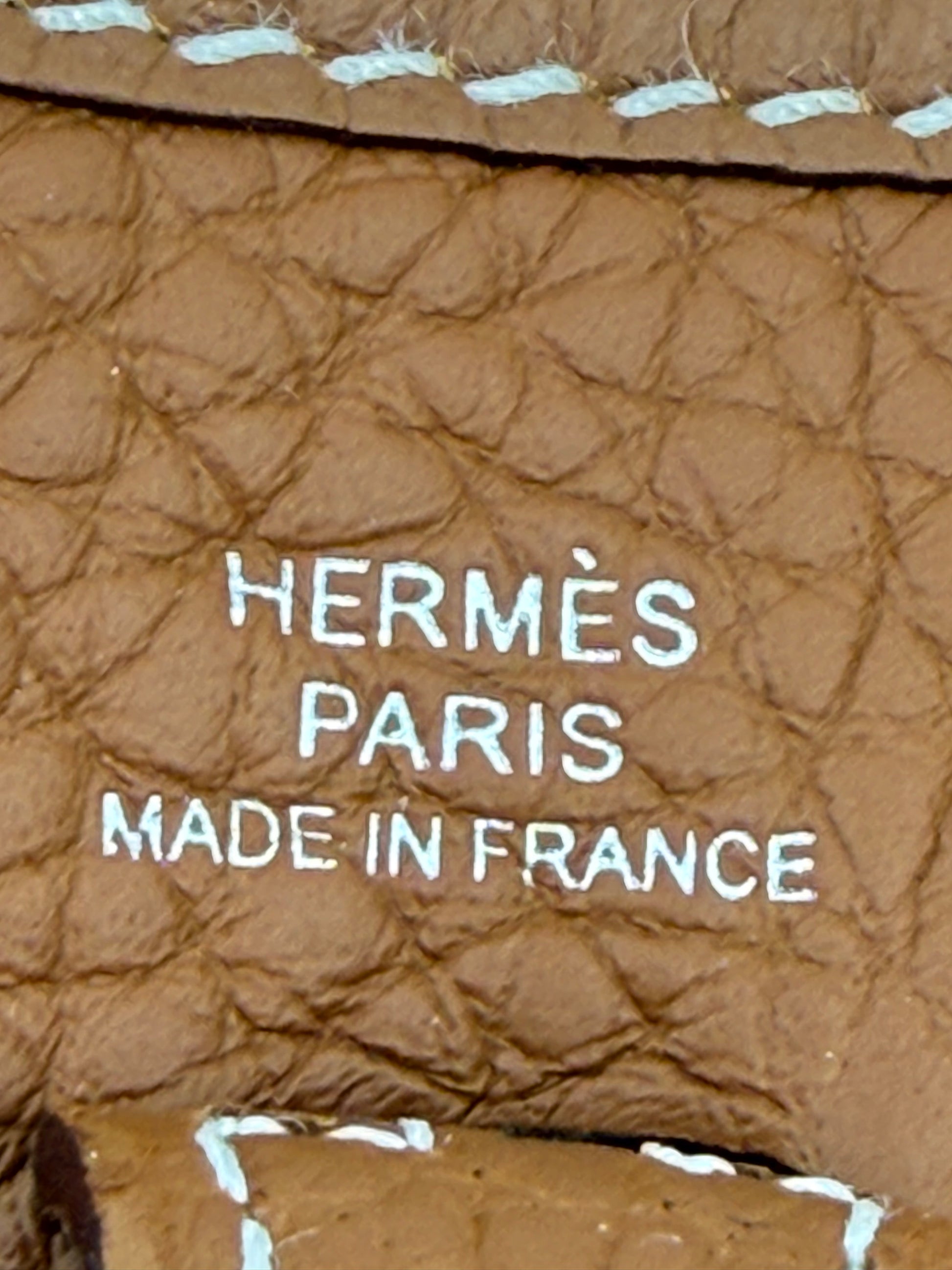 Prägung von HERMÈS Paris Made in France auf HERMÈS Evelyne 16 gold PHW Leder in Nahaufnahme.