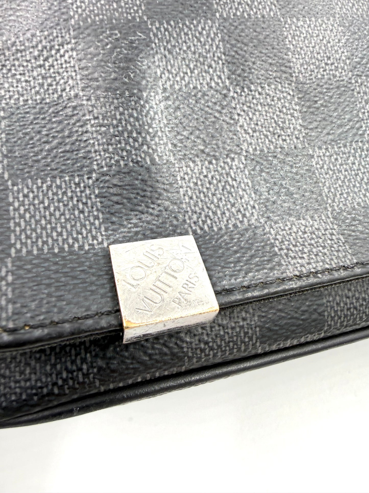 LOUIS VUITTON District Damier Graphite Nahaufnahme der Tasche mit schwarzem Karo-Canvas und silbernem Logo-Emblem