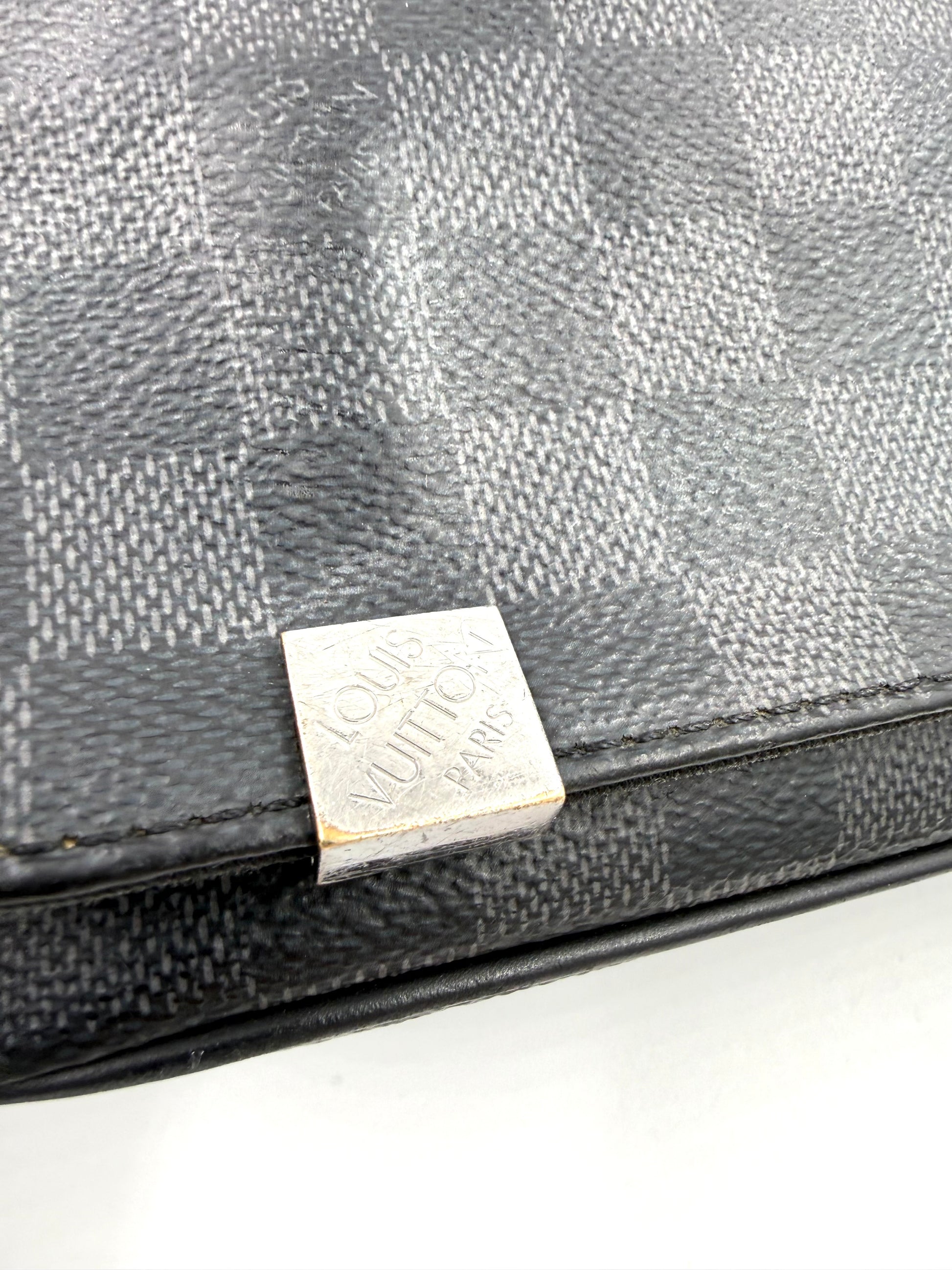 LOUIS VUITTON District Damier Graphite Nahaufnahme der Tasche mit schwarzem Karo-Canvas und silbernem Logo-Emblem