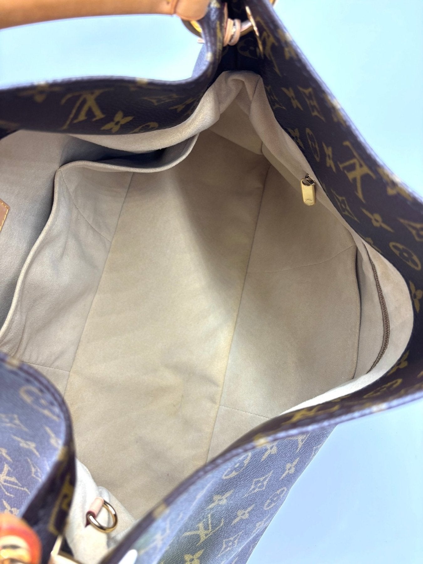 Louis Vuitton Artsy MM Monogram Canvas Handtasche mit beigem Innenfutter und mehreren Innenfachern, gezeigt von oben