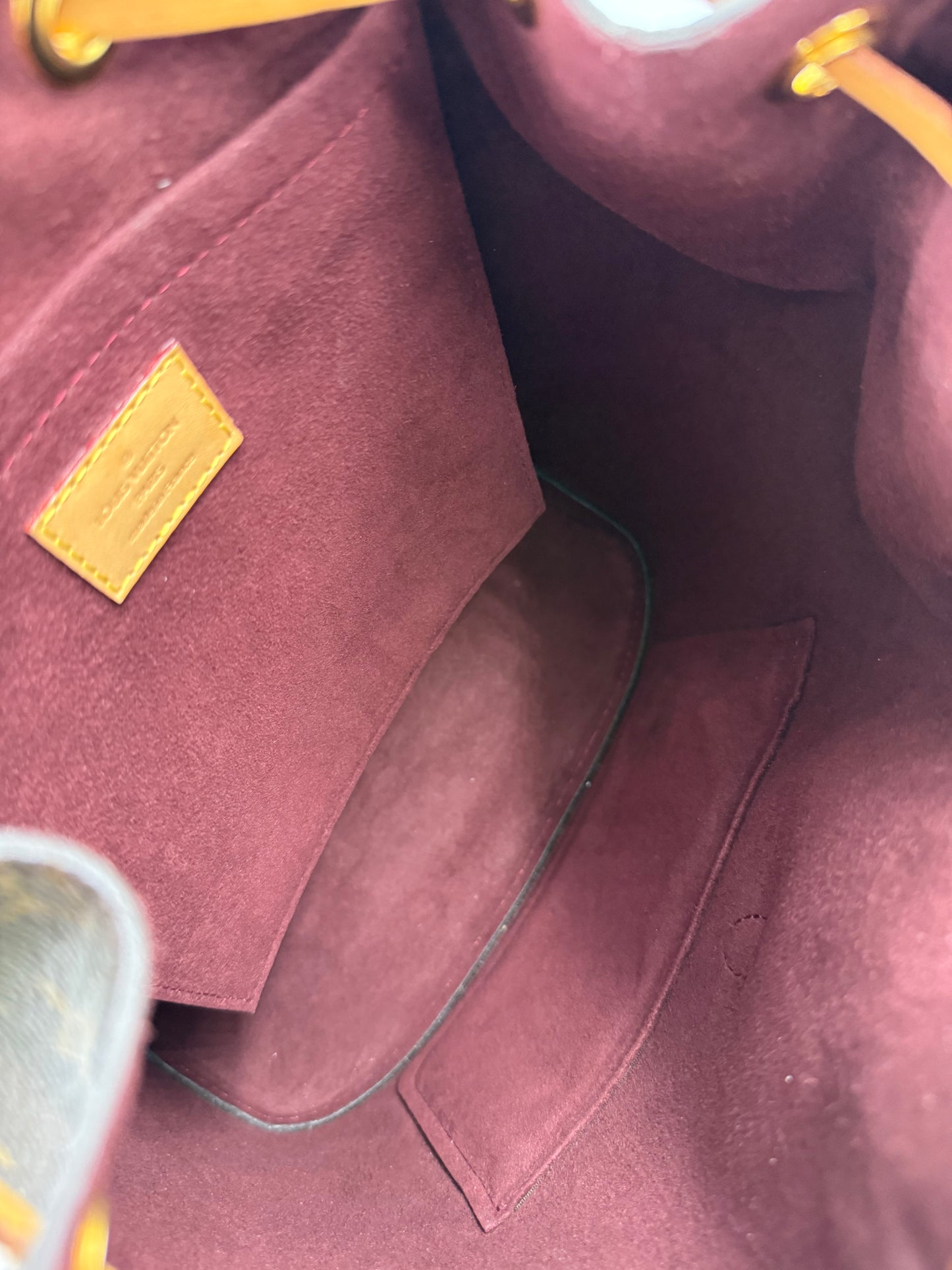 Innenansicht der LOUIS VUITTON Montsouris MM Monogram Canvas Handtasche mit weichem, burgunderfarbenem Innenfutter.