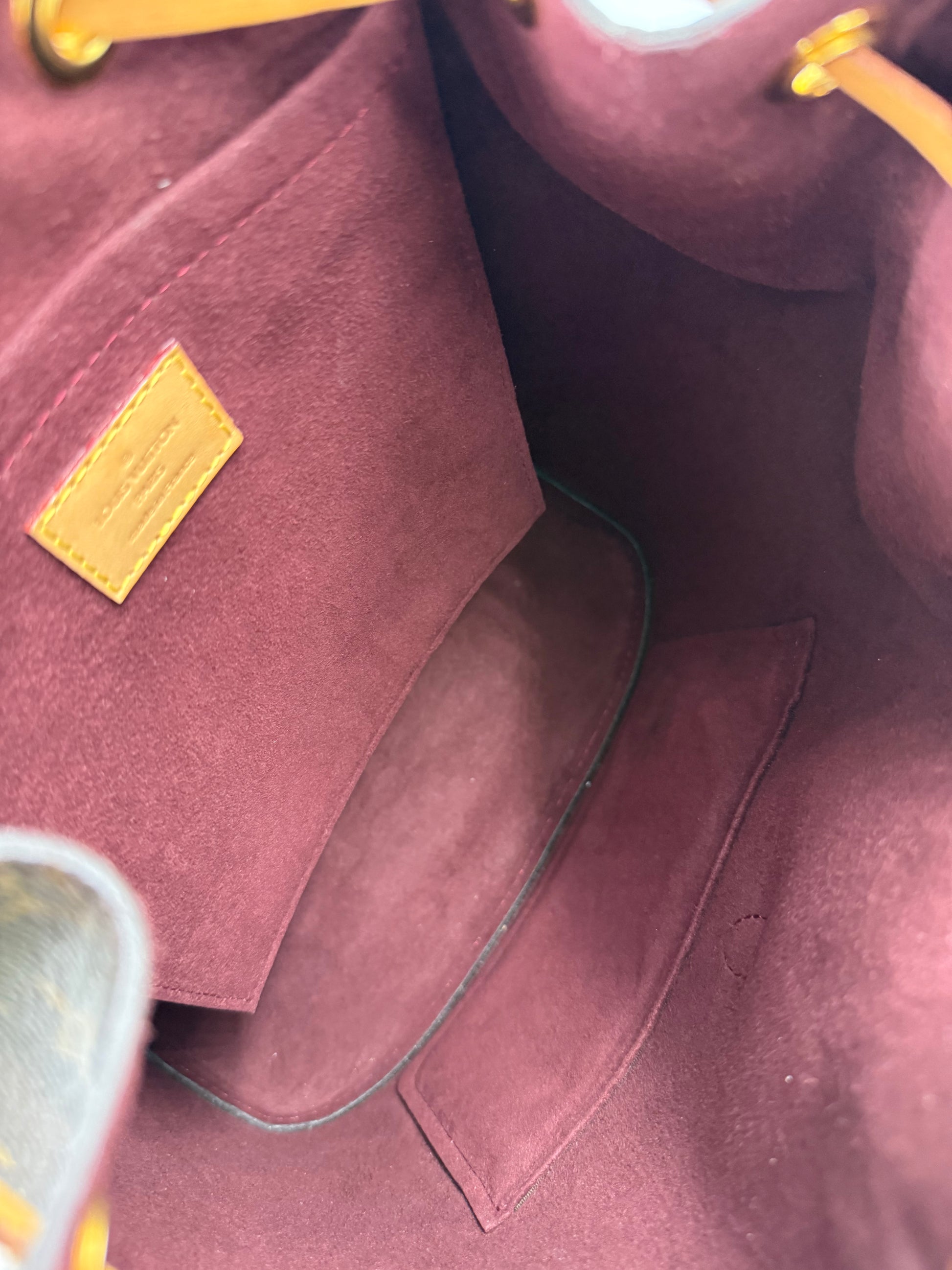 Innenansicht der LOUIS VUITTON Montsouris MM Monogram Canvas Handtasche mit weichem, burgunderfarbenem Innenfutter.
