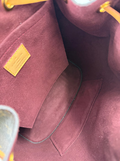 Innenansicht der LOUIS VUITTON Montsouris MM Monogram Canvas Handtasche mit weichem, burgunderfarbenem Innenfutter.