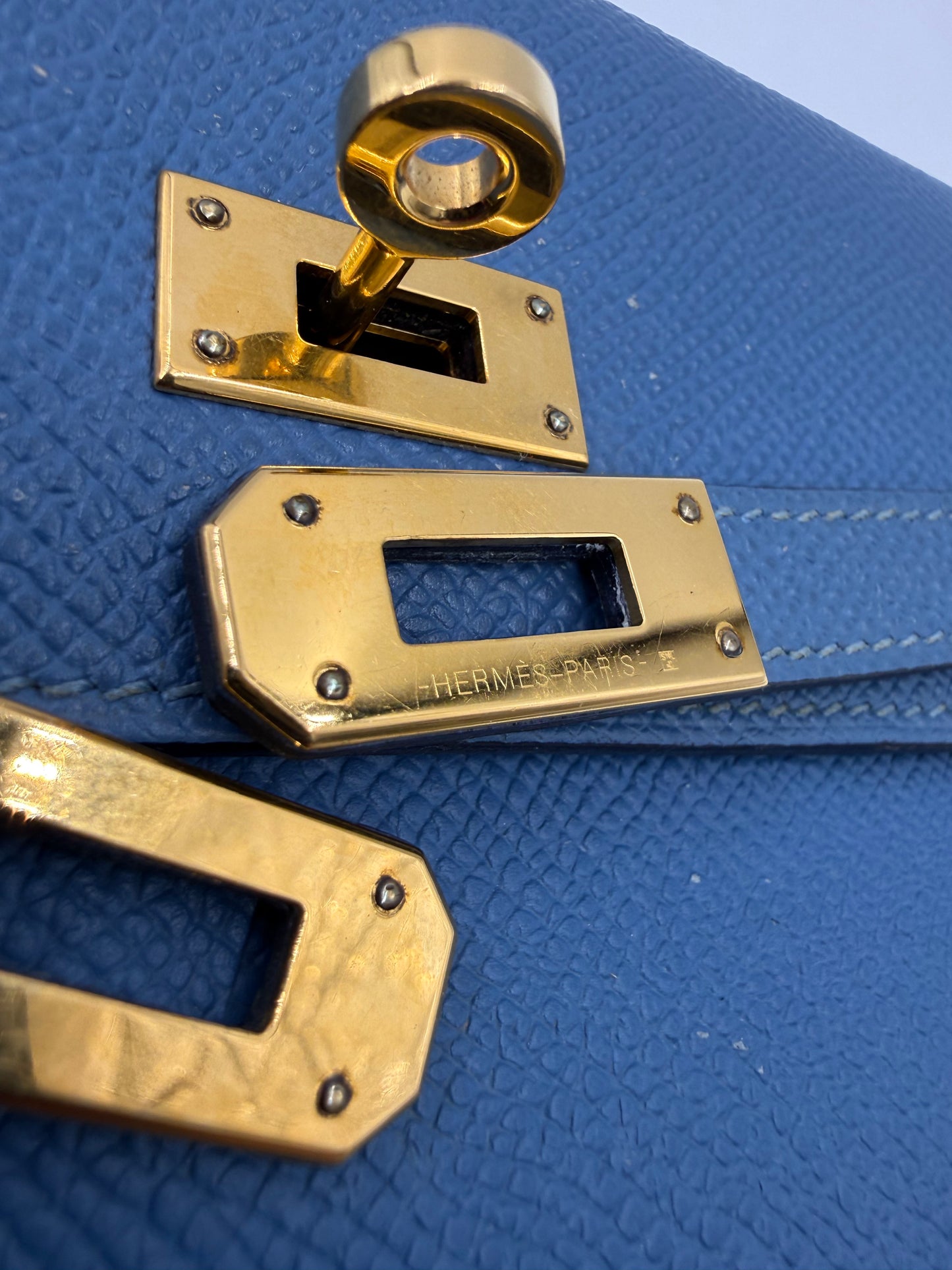 HERMÈS Kelly long Wallet Epsom Bleu Izmir GHW Detail des goldfarbenen Verschlusses auf blau genarbtem Leder