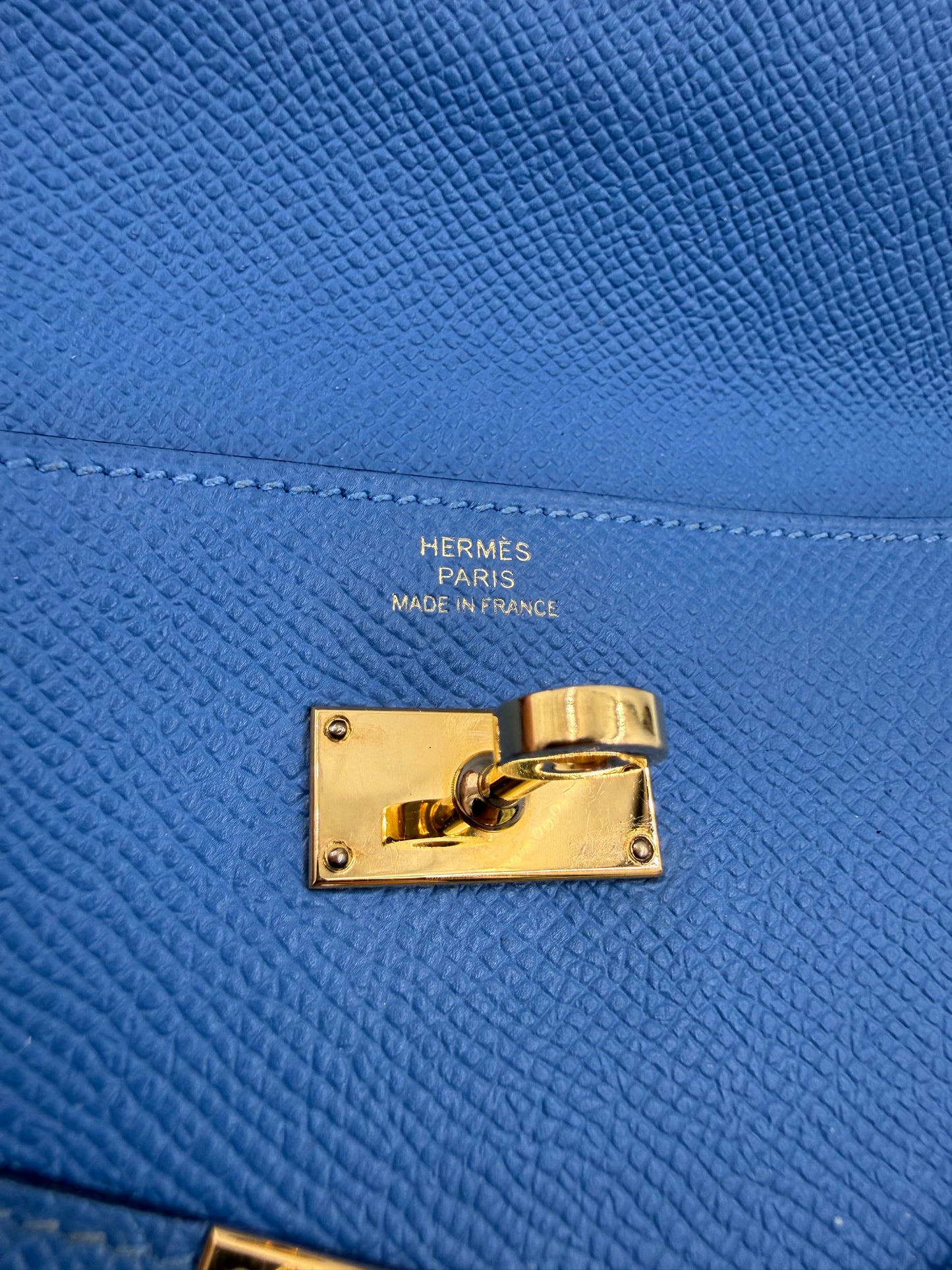 HERMÈS Kelly long Wallet Epsom Bleu Izmir GHW goldfarbener Drehverschluss auf blau genarbtem Leder mit Prägung Paris Made in France