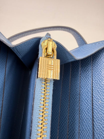 HERMÈS Kelly long Wallet Epsom Bleu Izmir GHW Reißverschluss und goldfarbener Schlossanhänger auf blauem Leder