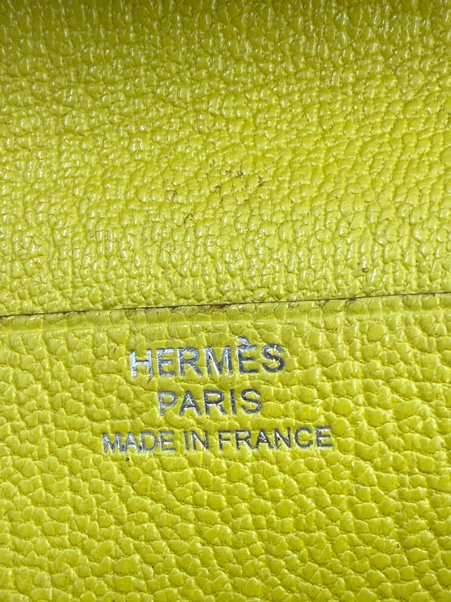 Nahe Aufnahme des Prägezugs auf dem HERMÈS Bearn Wallet Mysoreleder Lime PHW in leuchtendem Limettenton.