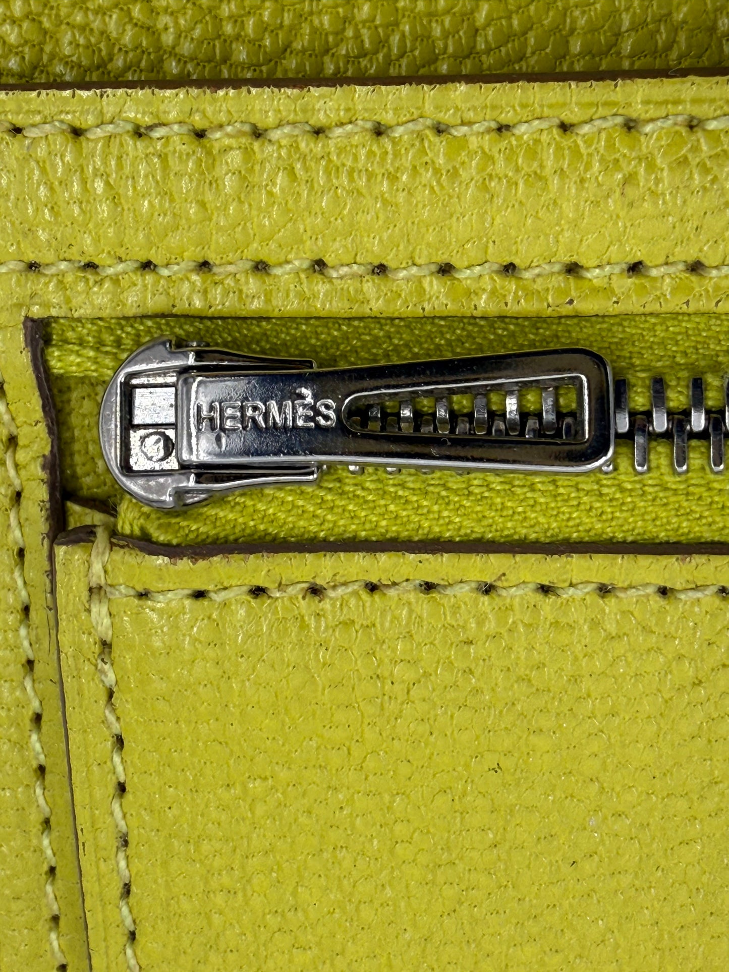 Detailaufnahme des Reißverschlusses der HERMÈS Bearn Wallet Mysoreleder Lime PHW in leuchtendem Limettengrün.