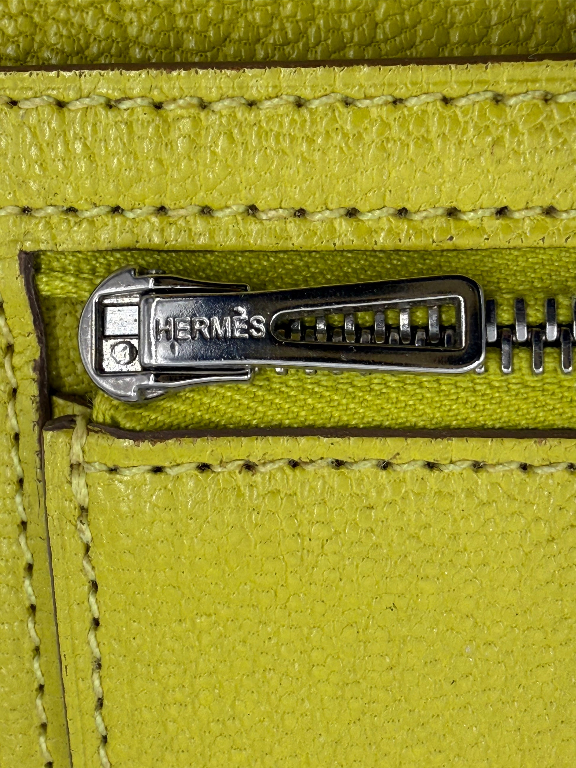 Detailaufnahme des Reißverschlusses der HERMÈS Bearn Wallet Mysoreleder Lime PHW in leuchtendem Limettengrün.