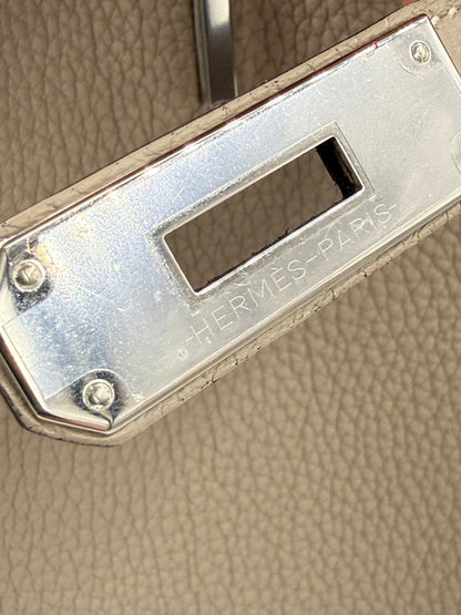 Detailaufnahme des Verschlusses mit Gravur von HERMÈS Birkin 40 Togo Gris Tourterelle PHW Handtasche.
