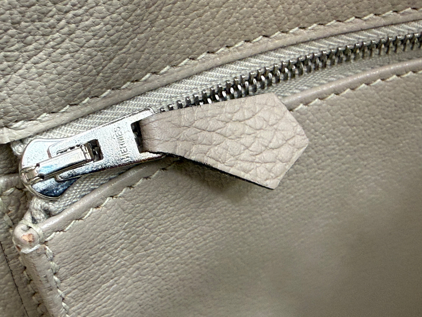 Detailaufnahme des Reißverschlusses einer HERMÈS Birkin 40 Togo Gris Tourterelle PHW Handtasche aus hochwertigem Leder.