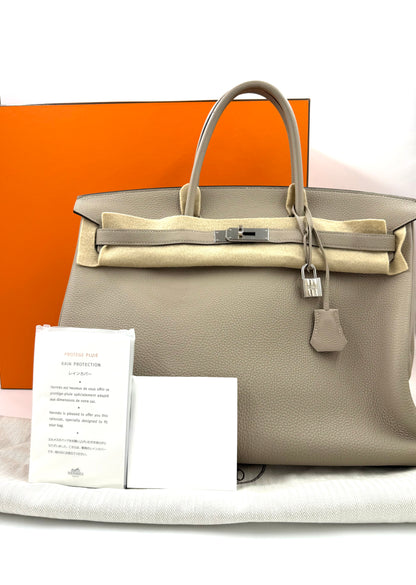 HERMÈS Birkin 40 Togo Gris Tourterelle PHW, elegante Designer Handtasche mit silberner Hardware vor orangefarbener Box