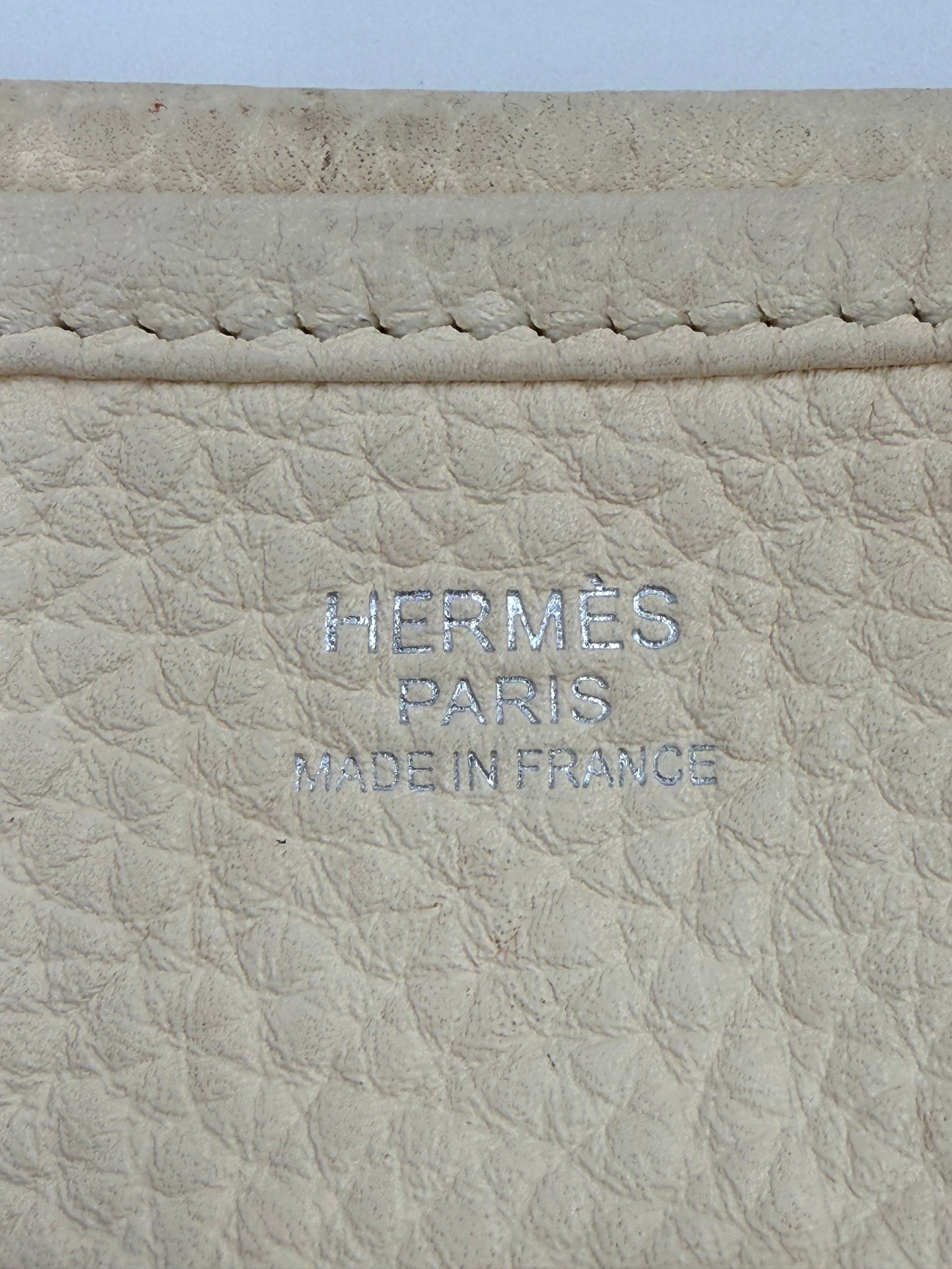 Detailaufnahme des Labels der HERMÈS Evelyne 29 Nata Clemence PHW aus hochwertigem beigem Leder.