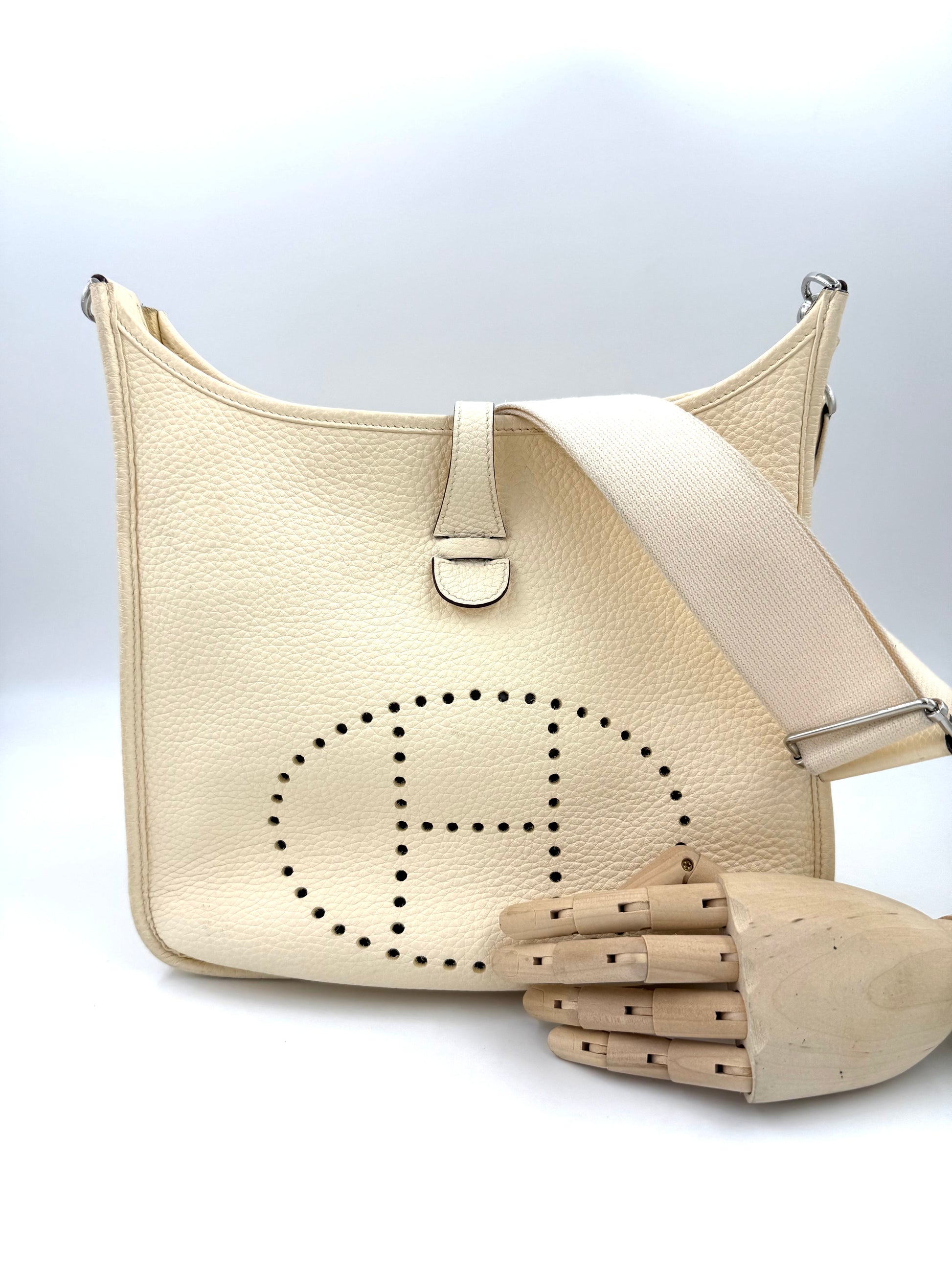 Cremefarbene HERMÈS Evelyne 29 Nata Clemence PHW Designer-Handtasche mit gestreiftem Schulterriemen und Perforation.