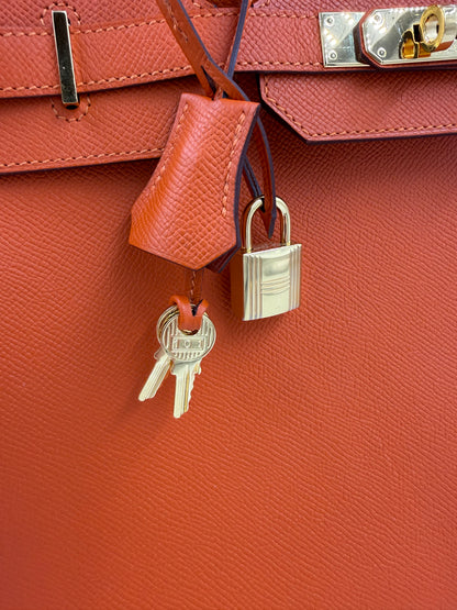 Detailaufnahme der HERMÈS Birkin 35 Epsom orange GHW mit Schloss und Schlüsseln, Galerieposition 9, Hochformat.