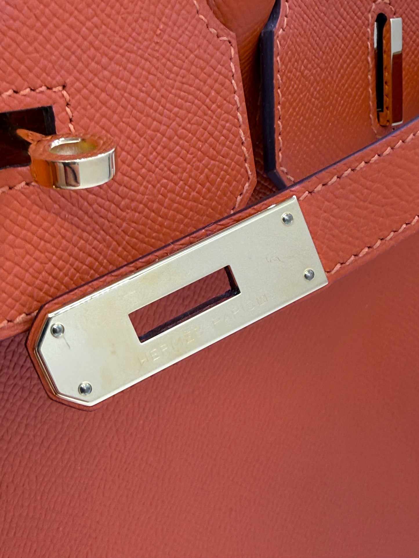 Detailaufnahme der Verschlussplatte der HERMÈS Birkin 35 Epsom orange GHW, Galerieposition 10, Portraitformat