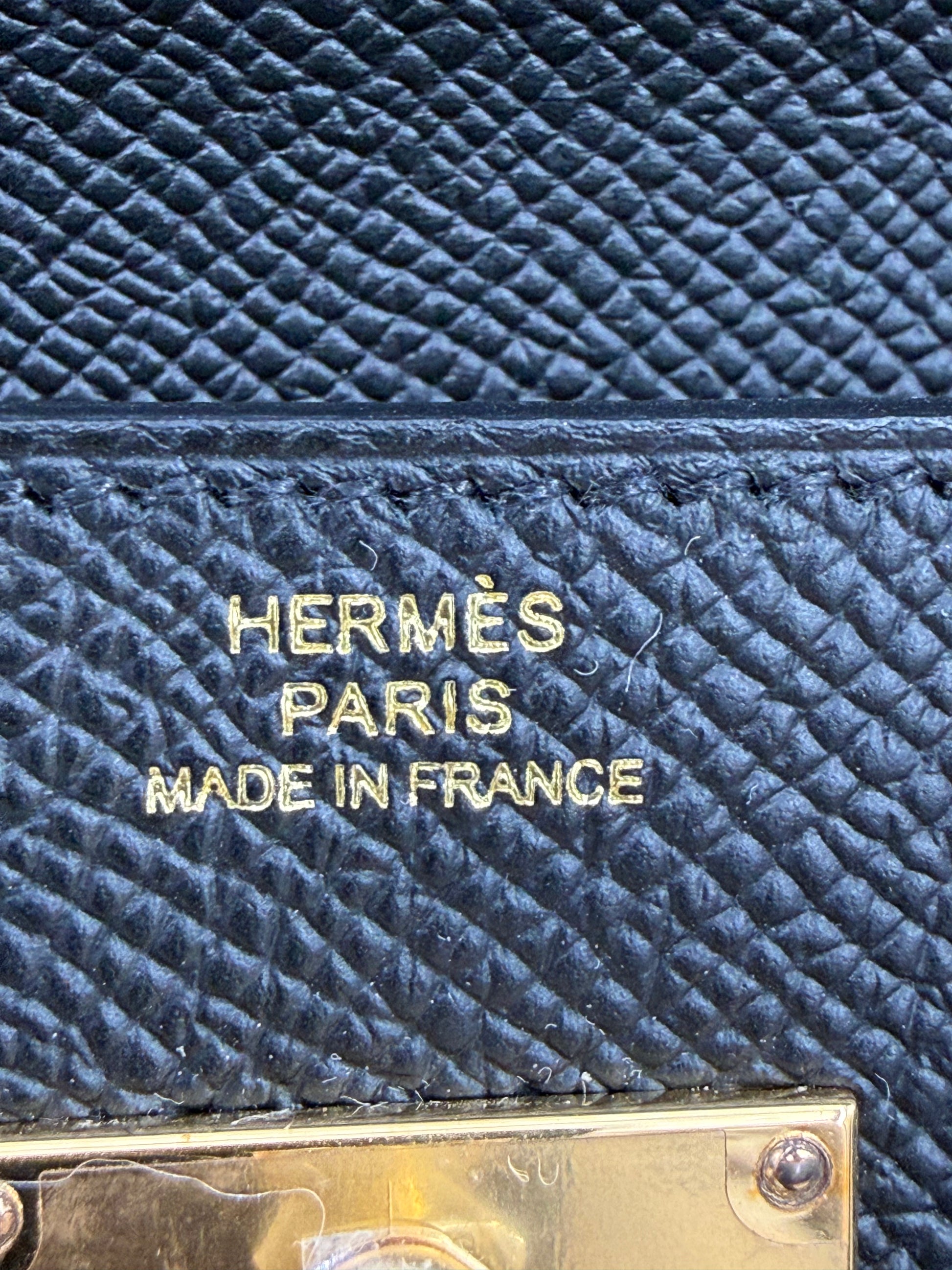 HERMÈS Kelly to Go Epsom schwarz GHW Detail der goldfarbenen Prägung auf genarbtem Leder in Schwarz