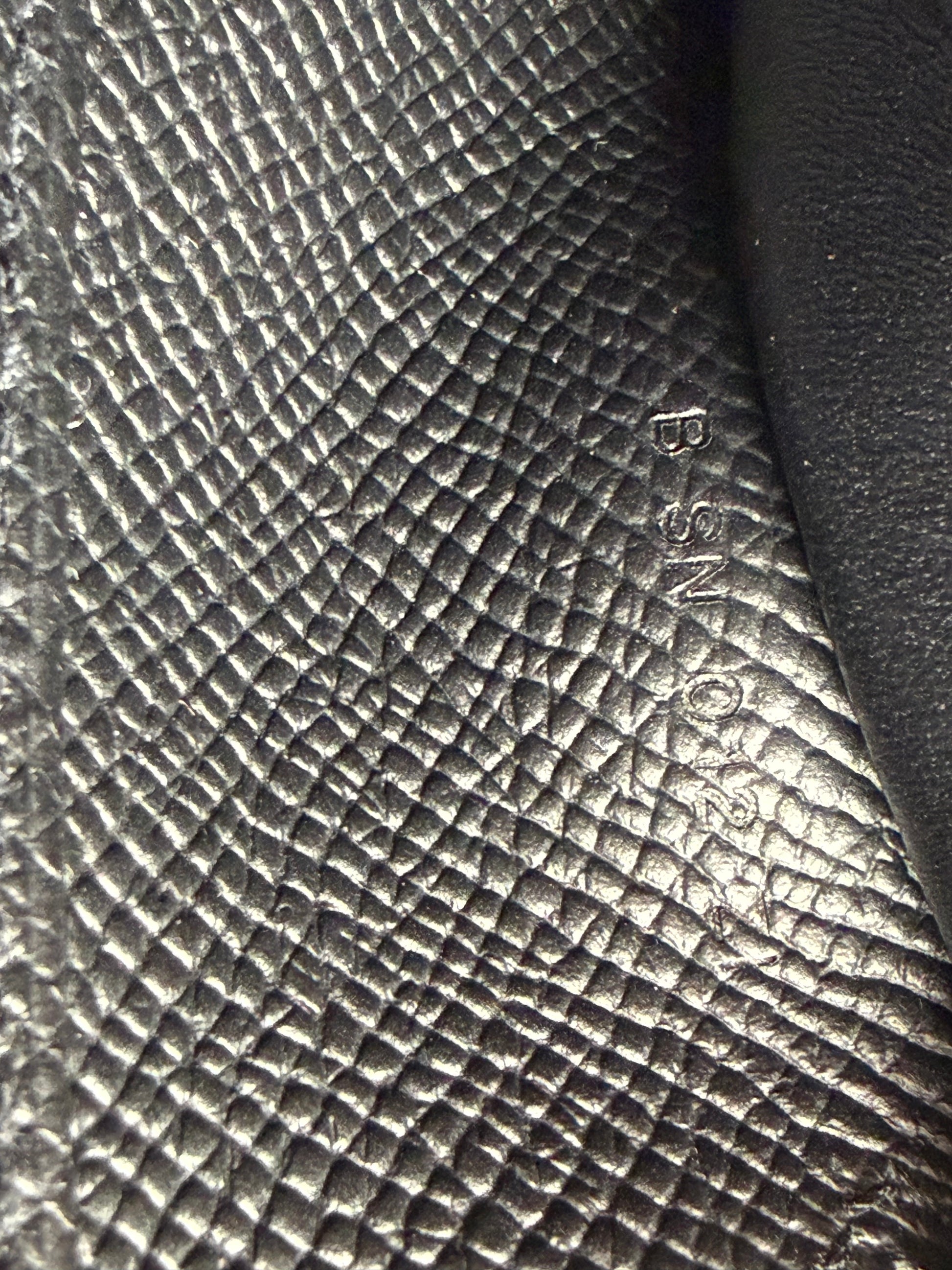 HERMÈS Kelly to Go Epsom schwarz GHW Detail des genarbten Leders mit Seriennummerprägung in Schwarz