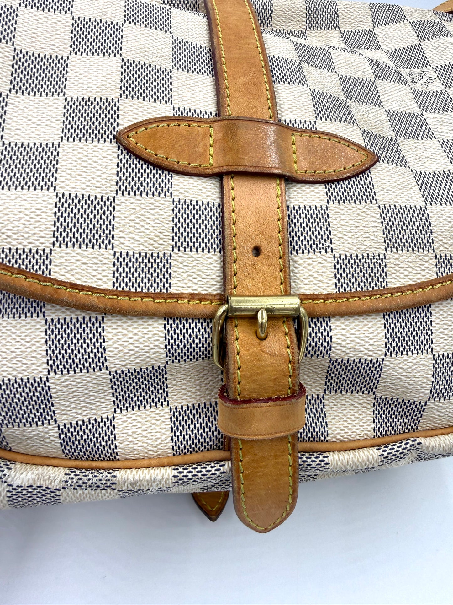 LOUIS VUITTON Saumur 30 Damier Azur Detailaufnahme des Lederriemens mit goldfarbener Schnalle und charakteristischem Canvasmuster