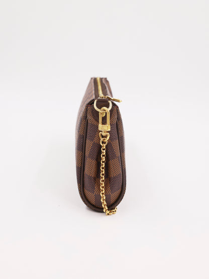 LOUIS VUITTON Pochette Eva Damier Ebene als braune Clutch mit goldener Kette in Seitenansicht